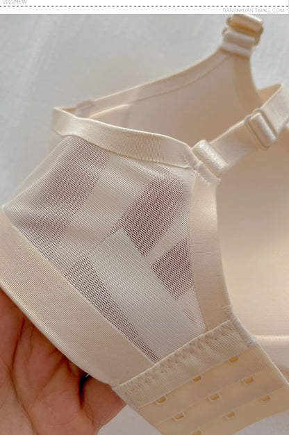 Close-up of a hand holding a white wireless push-up bra with thin cup mesh and adjustable straps