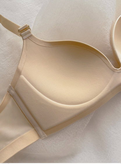 Close-up of beige wireless push-up bra with thin cup and seamless design on white textured background