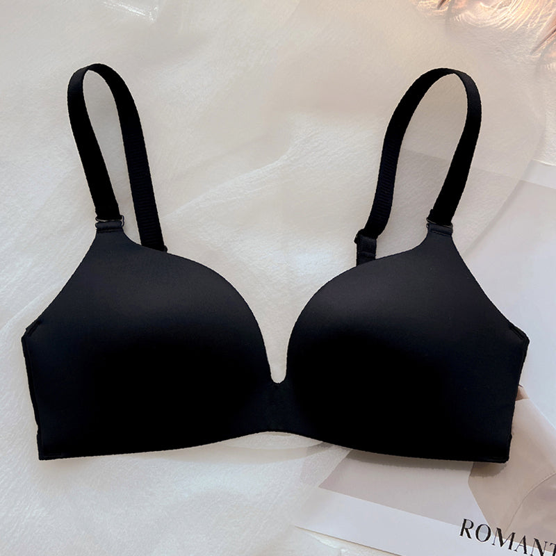 Black wireless push-up bra with thin cups and adjustable straps on white fabric background