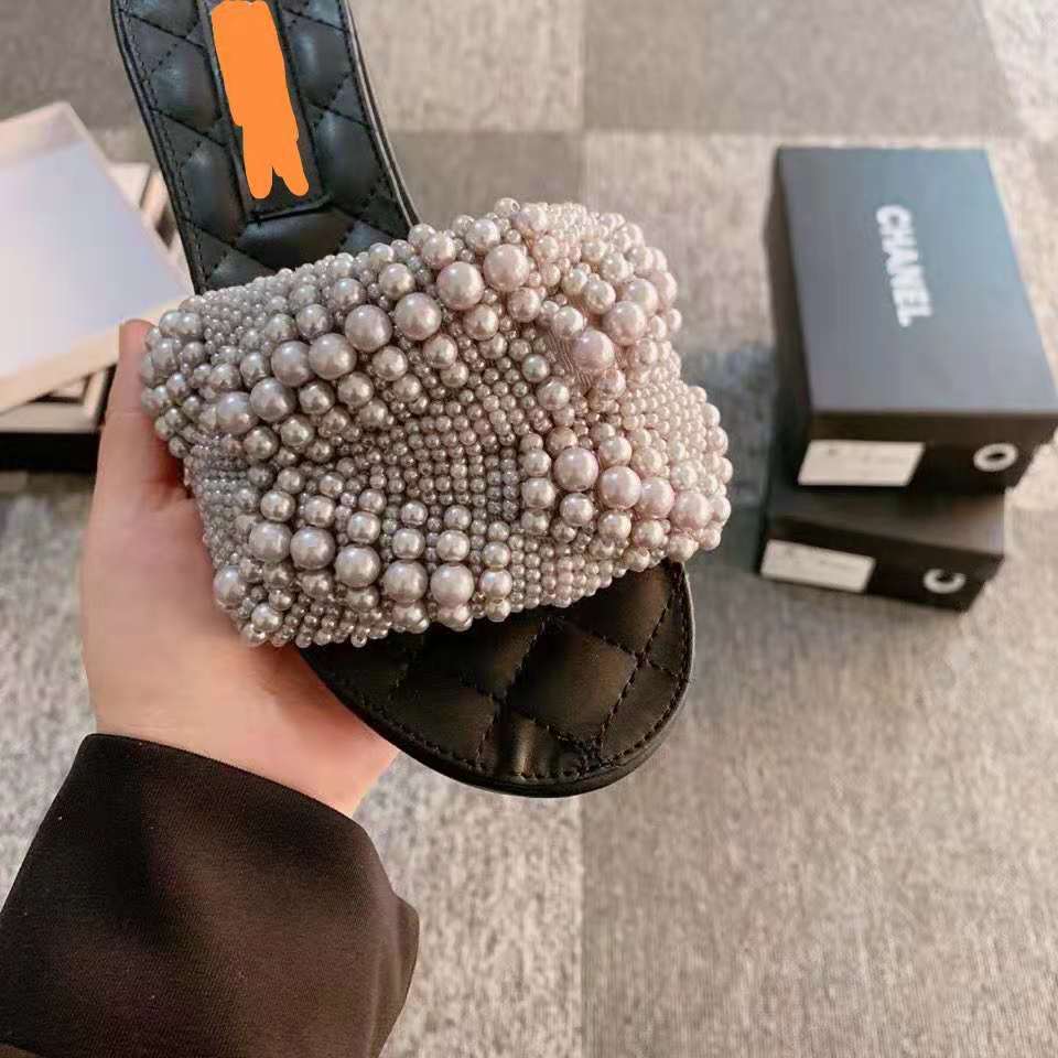 Black flat sandal with quilted sole and strap embellished with clustered white pearls