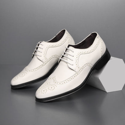 White men's casual leather dress shoes with brogue detailing and black rubber sole on gray background