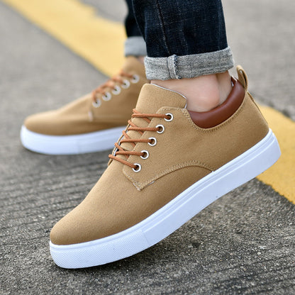 Men's beige canvas sneakers with brown leather collar and white rubber sole on asphalt