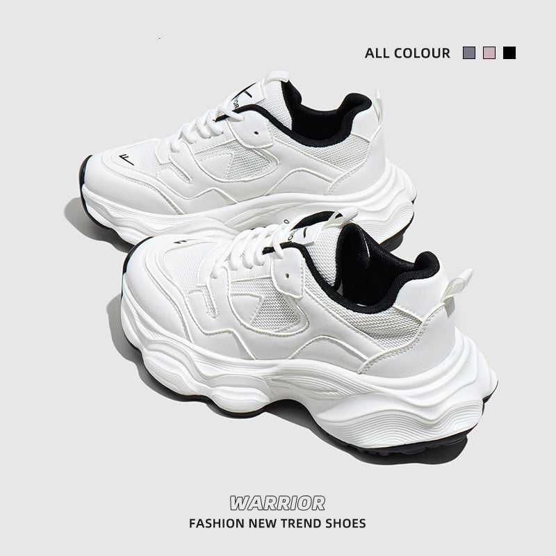 White and black women's mesh sneakers with chunky sole and lace-up design on gray background