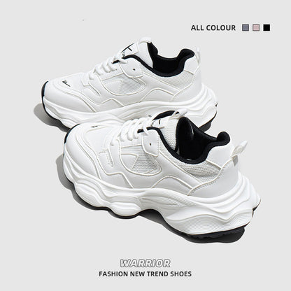 White and black women's mesh sneakers with chunky sole and lace-up design on gray background