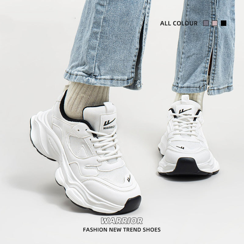 White and black chunky mesh sneakers with lace-up design, worn with beige socks and cropped jeans