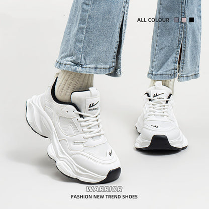 White and black chunky mesh sneakers with lace-up design, worn with beige socks and cropped jeans