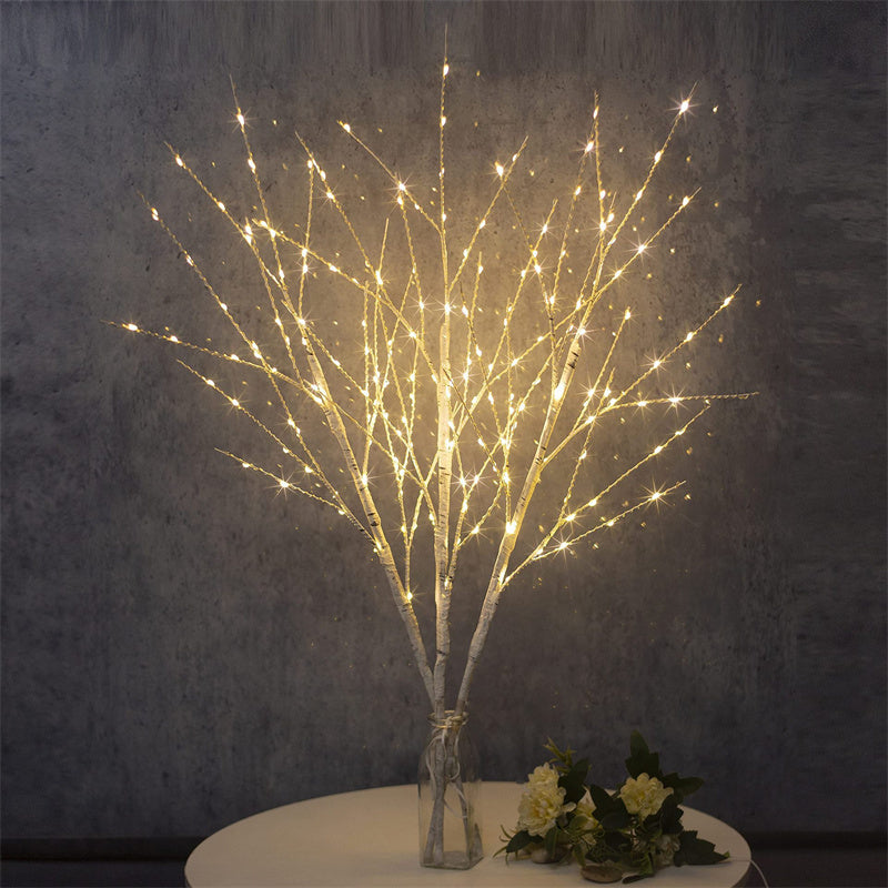 White birch tree LED decorative lights with warm white bulbs in glass vase on round table