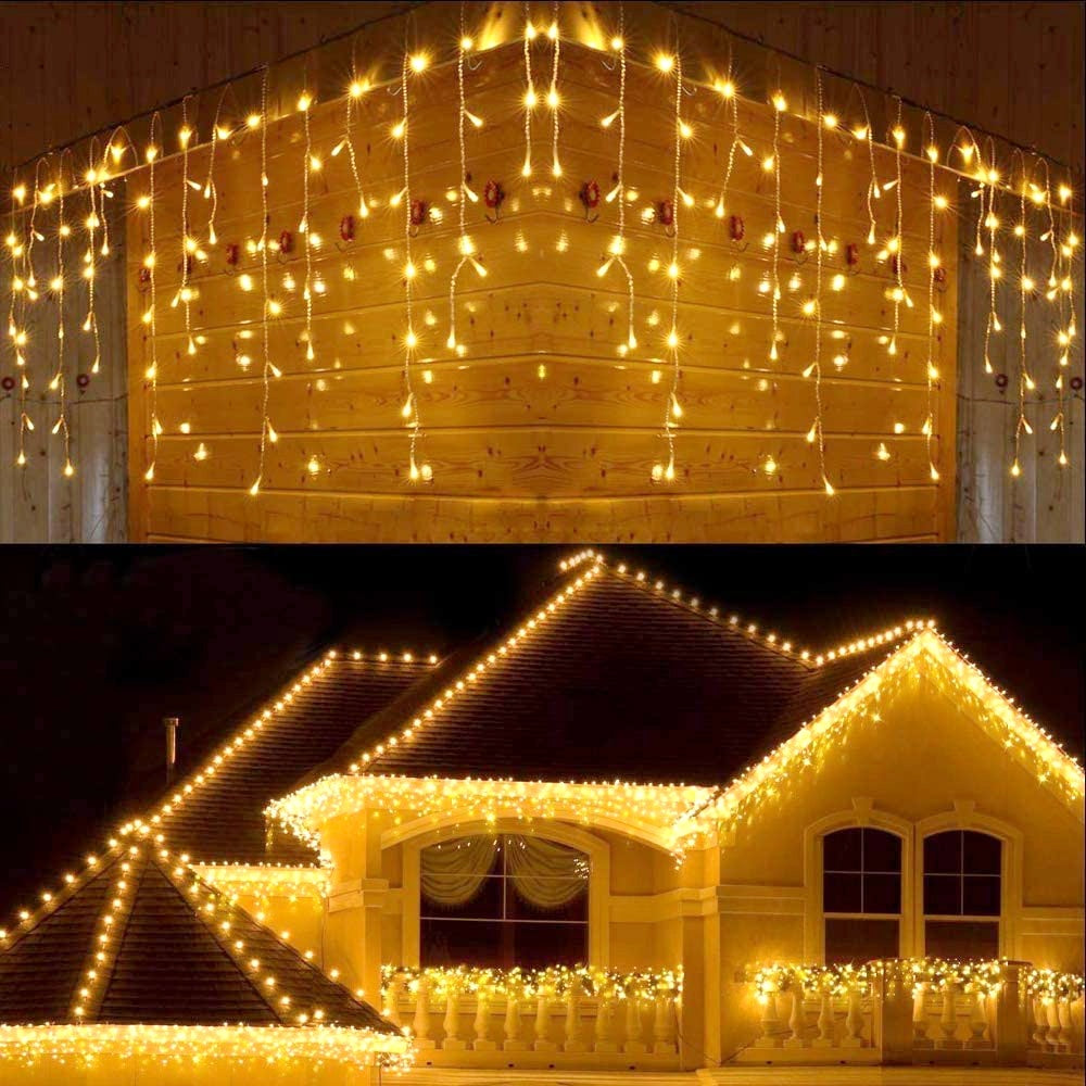 Warm white LED icicle string lights hanging indoors and decorating a house exterior roofline and balcony at night
