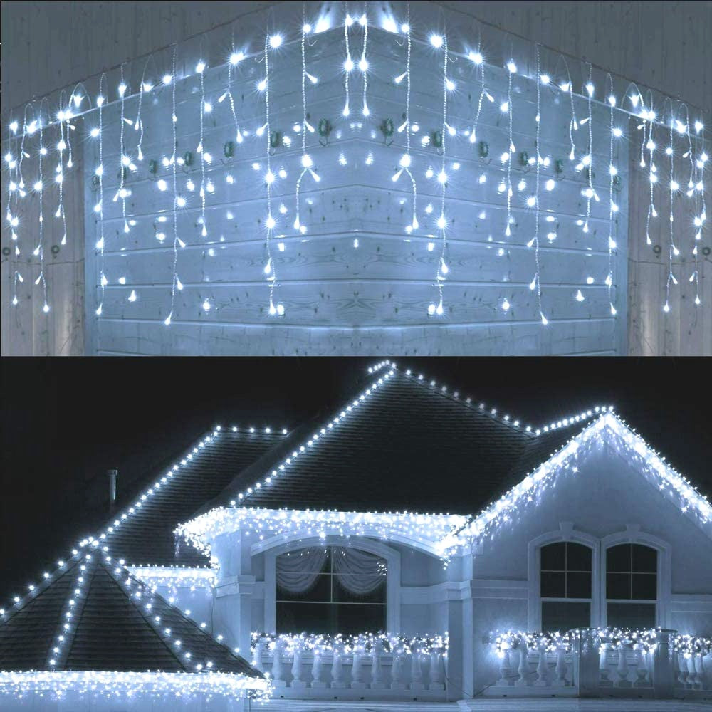 Warm white LED icicle Christmas string lights hanging outdoors on a house roof and balcony at night