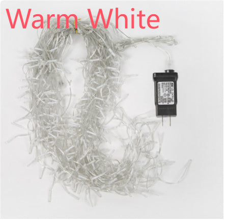 Warm white LED icicle string lights with clear wires and a black power adapter on white background