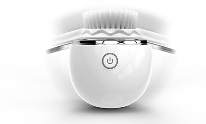 White ultrasonic electric face washer with soft bristles and power button on glossy surface