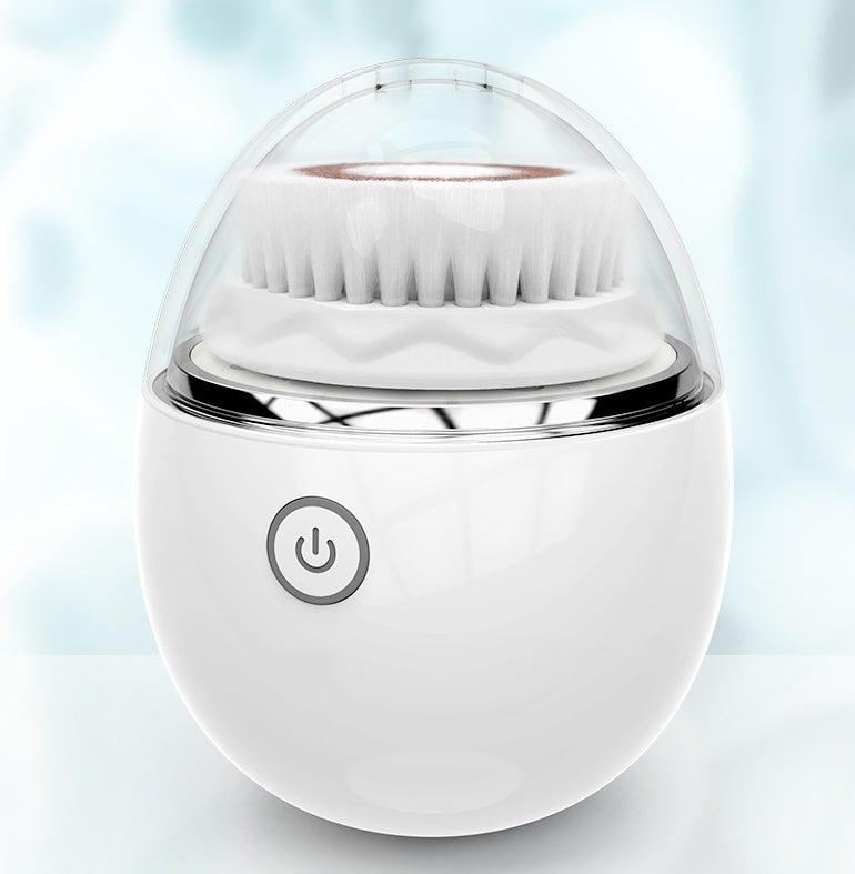 White ultrasonic electric face washer with soft bristles and power button, in clear protective cover