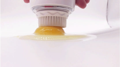 Ultrasonic electric face washer with white bristles cleaning a sticky yellow substance on white surface