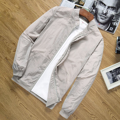 Lightweight beige men's sun protection jacket with zip front and ribbed cuffs on wooden surface