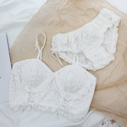 White lace cotton bra and matching high-waist panties set laid on beige fabric