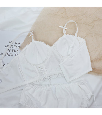 White lace cotton bra set with adjustable straps and matching white bottoms on beige and white background
