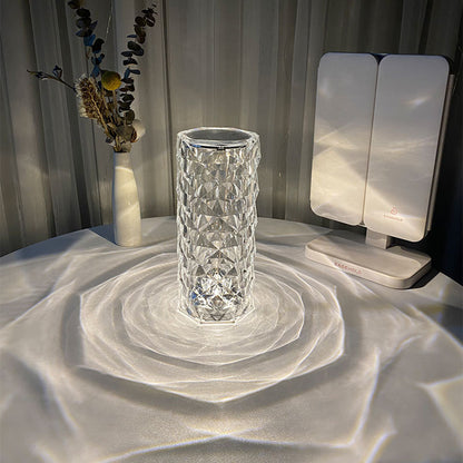 White USB crystal table lamp with acrylic shade creating soft glowing light and reflections on white surface
