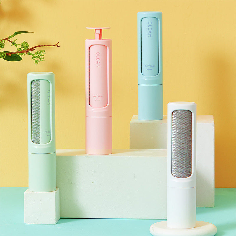 Set of reusable pet hair remover brushes in pastel colors on white blocks against yellow background