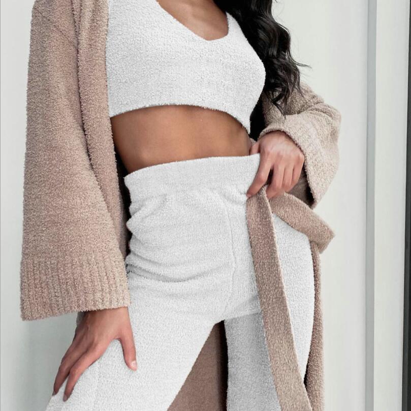 Woman wearing white velvet pajama set with crop top and high-waisted shorts, beige cozy cardigan