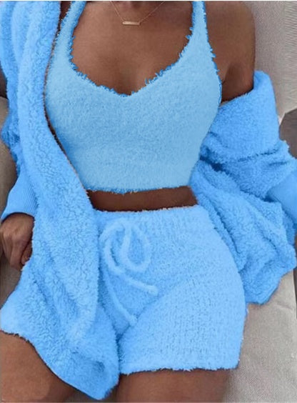 Woman wearing light blue soft velvet crop top, drawstring shorts, and matching cardigan loungewear set