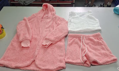 Soft pink hooded robe, pink drawstring shorts, and white sleeveless crop top on gray table