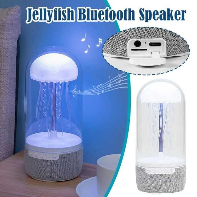 White jellyfish Bluetooth speaker with dome-shaped light and gray fabric base on wooden table