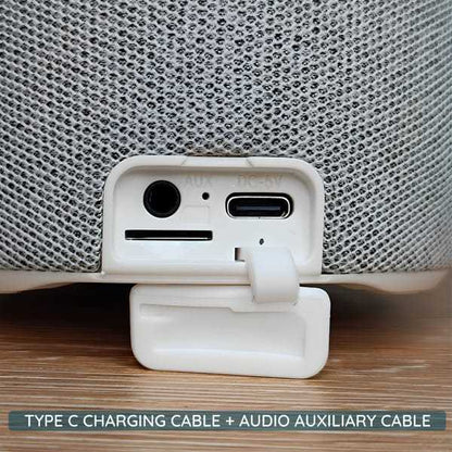 Close-up of white Bluetooth speaker ports showing AUX input and Type C charging cable slot on wooden surface