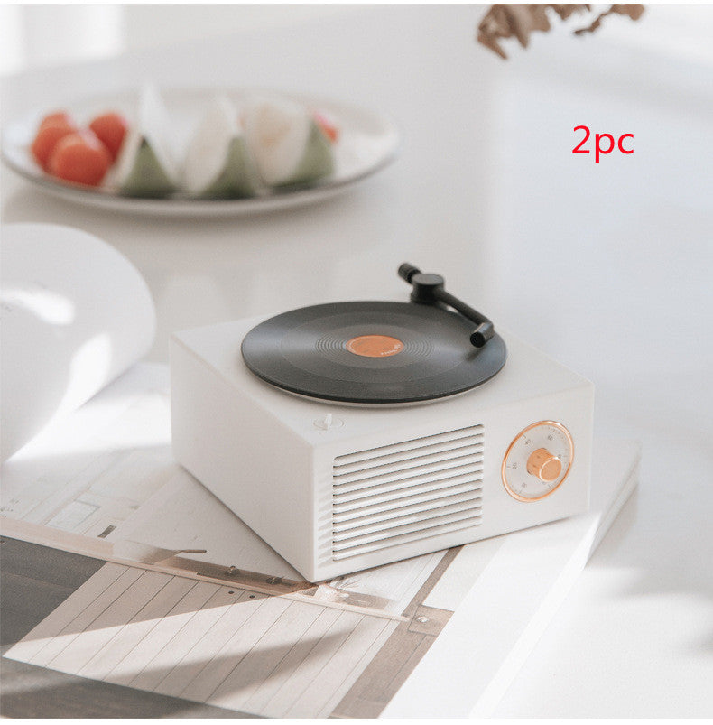 White Trendoligy retro mini phonograph and portable Bluetooth speaker with black vinyl record on white table