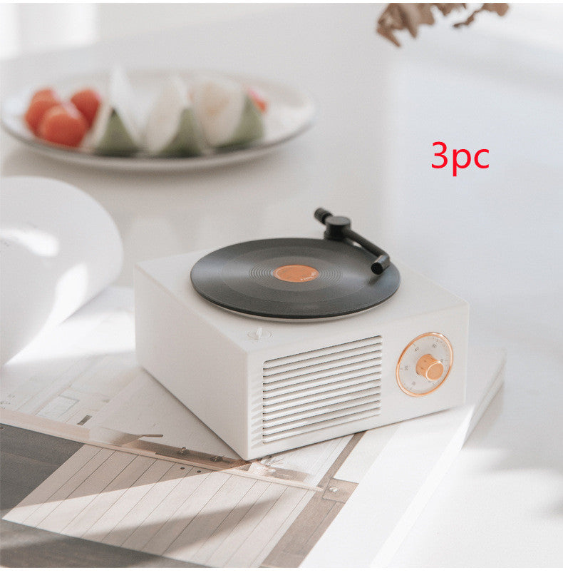 White Trendoligy retro mini phonograph Bluetooth speaker on a table with vinyl record and tone arm