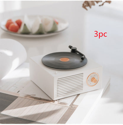 White Trendoligy retro mini phonograph Bluetooth speaker on a table with vinyl record and tone arm