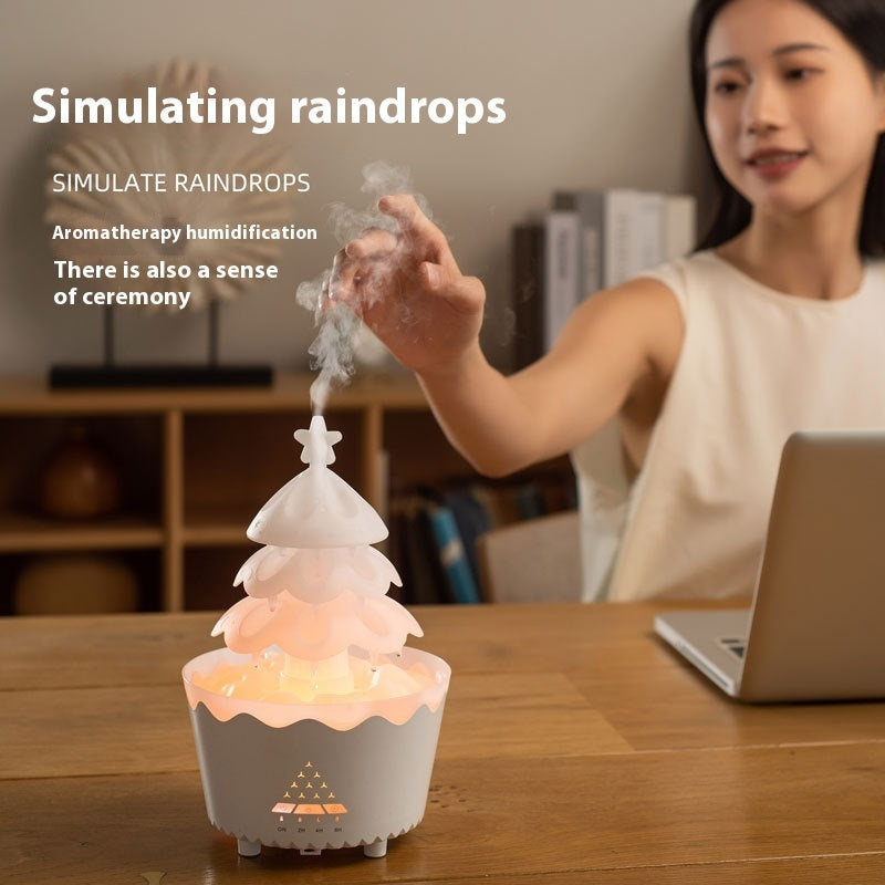 White aroma diffuser with warm glow on wooden table emitting mist, woman interacting nearby with laptop