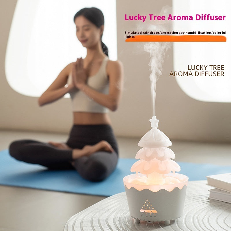 White Lucky Tree aroma diffuser with mist and colorful lights on table, woman meditating in background