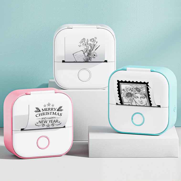 Three compact portable mini thermal printers in white with pink, white, and blue edges printing black and white images and text