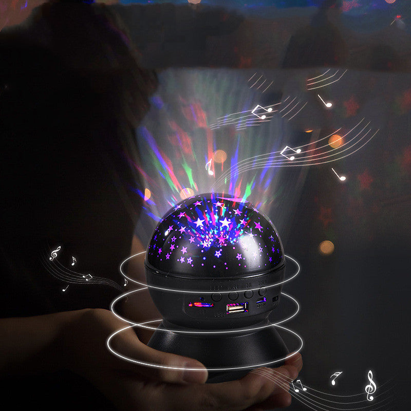 Person holding a black Bluetooth star projector night light with colorful star and music note projections
