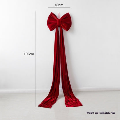 Large wine red velvet Christmas bow decoration with long flowing tails, 40cm wide and 180cm long