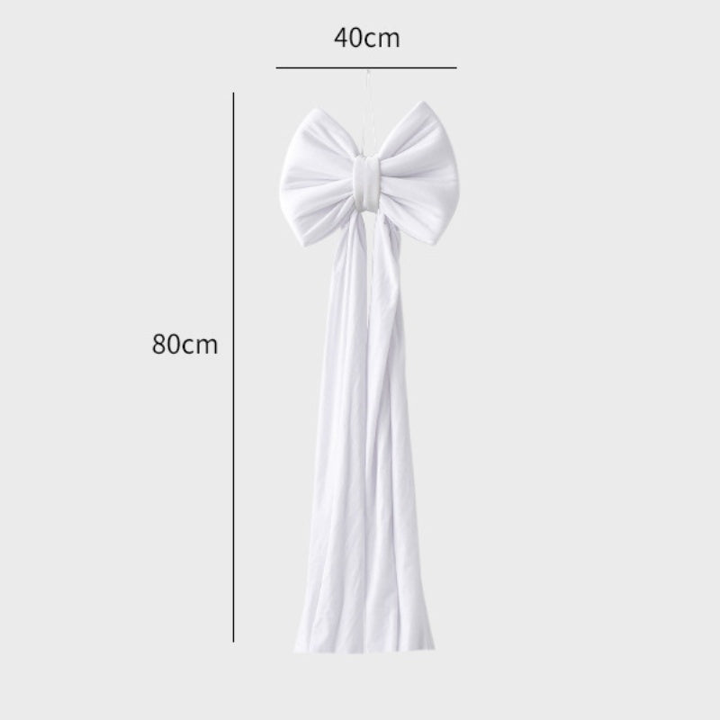 white velvet large Christmas bow decoration measuring 40cm by 80cm on gray background