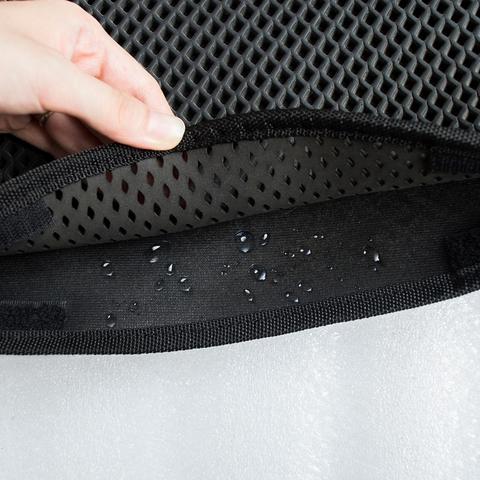 Close-up of black waterproof EVA cat litter mat with honeycomb design and water droplets inside