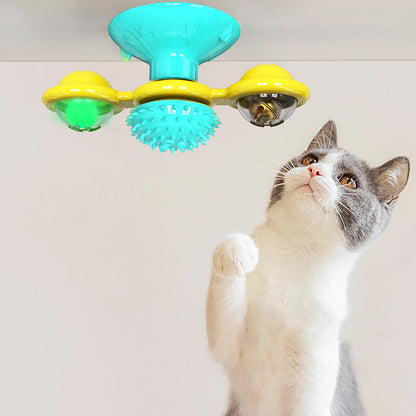 Gray and white cat reaching up to a colorful suction cup interactive cat toy with spinning elements