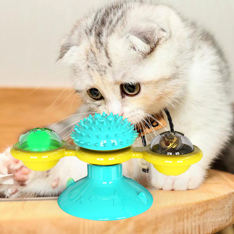 Kitten playing with interactive catnip suction cup toy featuring a rotating blue spiked center and yellow arms