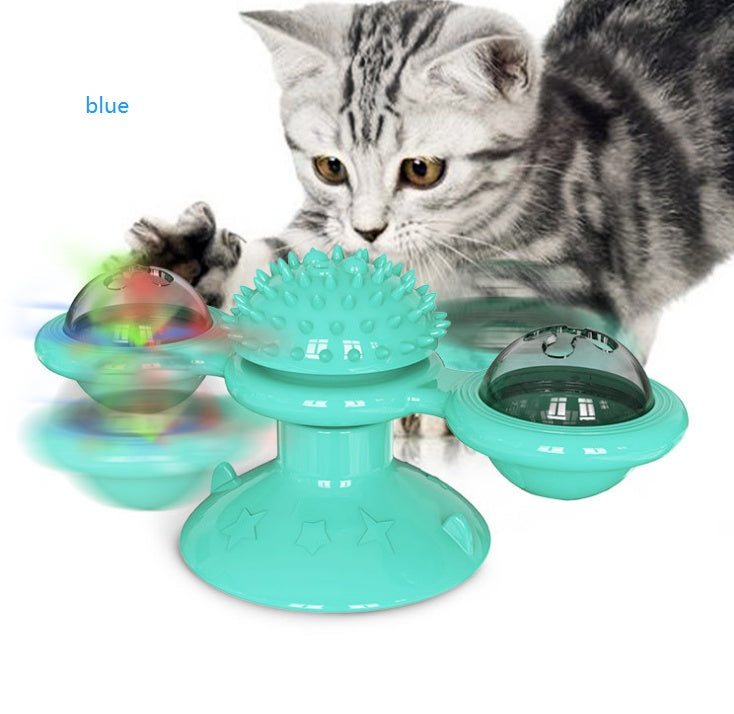Gray tabby kitten playing with blue interactive cat toy with spinning parts and suction cup base