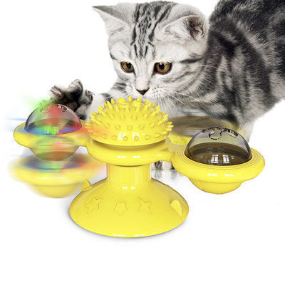 Gray tabby kitten playing with yellow interactive cat toy featuring suction cup and spinning parts