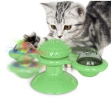 Gray tabby cat playing with rotating green windmill catnip toy with suction cup base