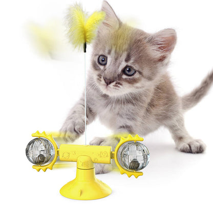 Grey kitten playing with interactive yellow catnip suction cup toy with rotating balls and feathers