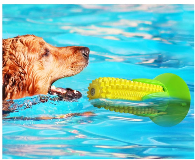 Golden retriever swimming towards yellow corn-shaped interactive dog chew toy in pool water