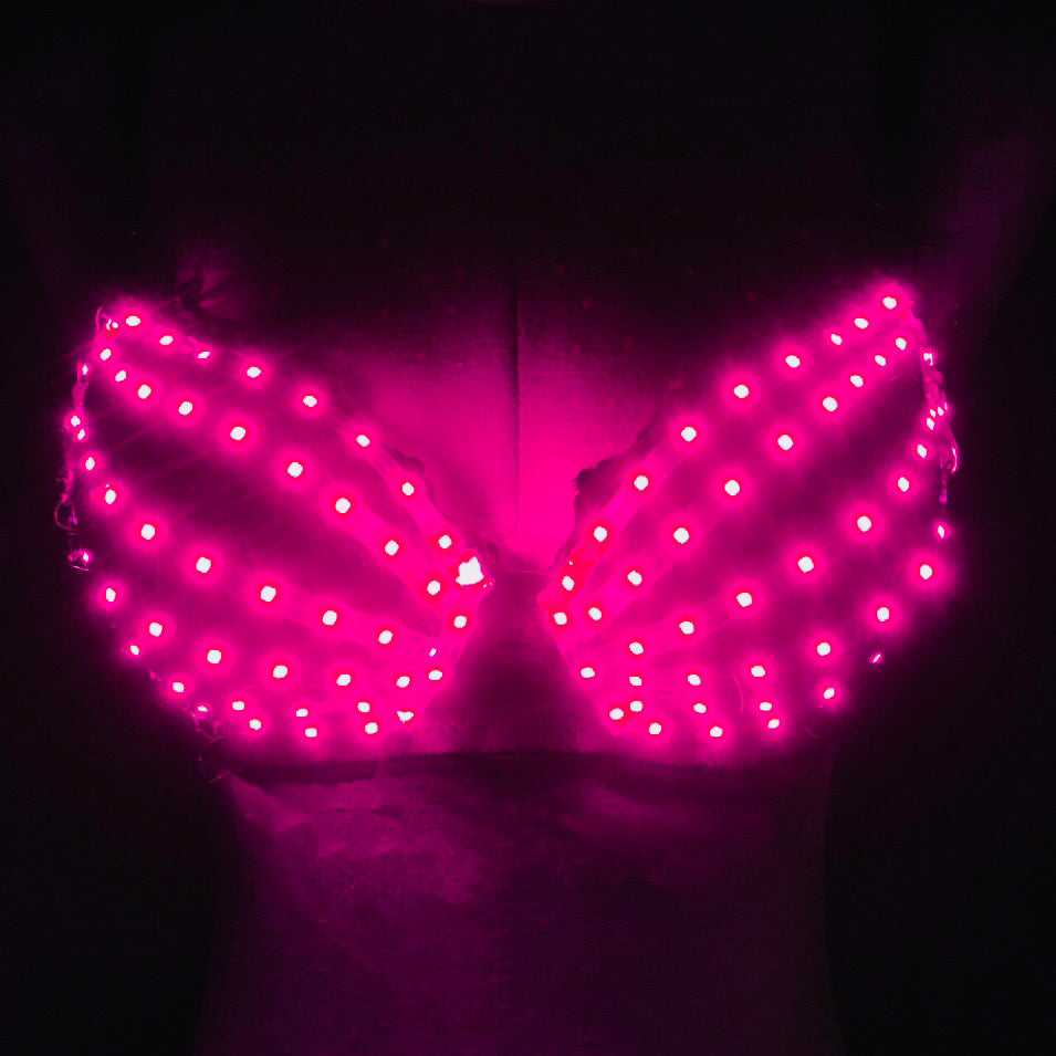 Pink LED light-up bra on mannequin in dark setting with bright neon glow