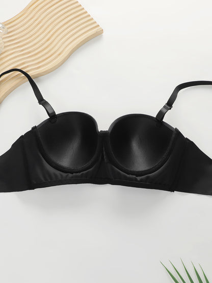 Black padded push-up bra with adjustable straps on white surface with wooden textured board