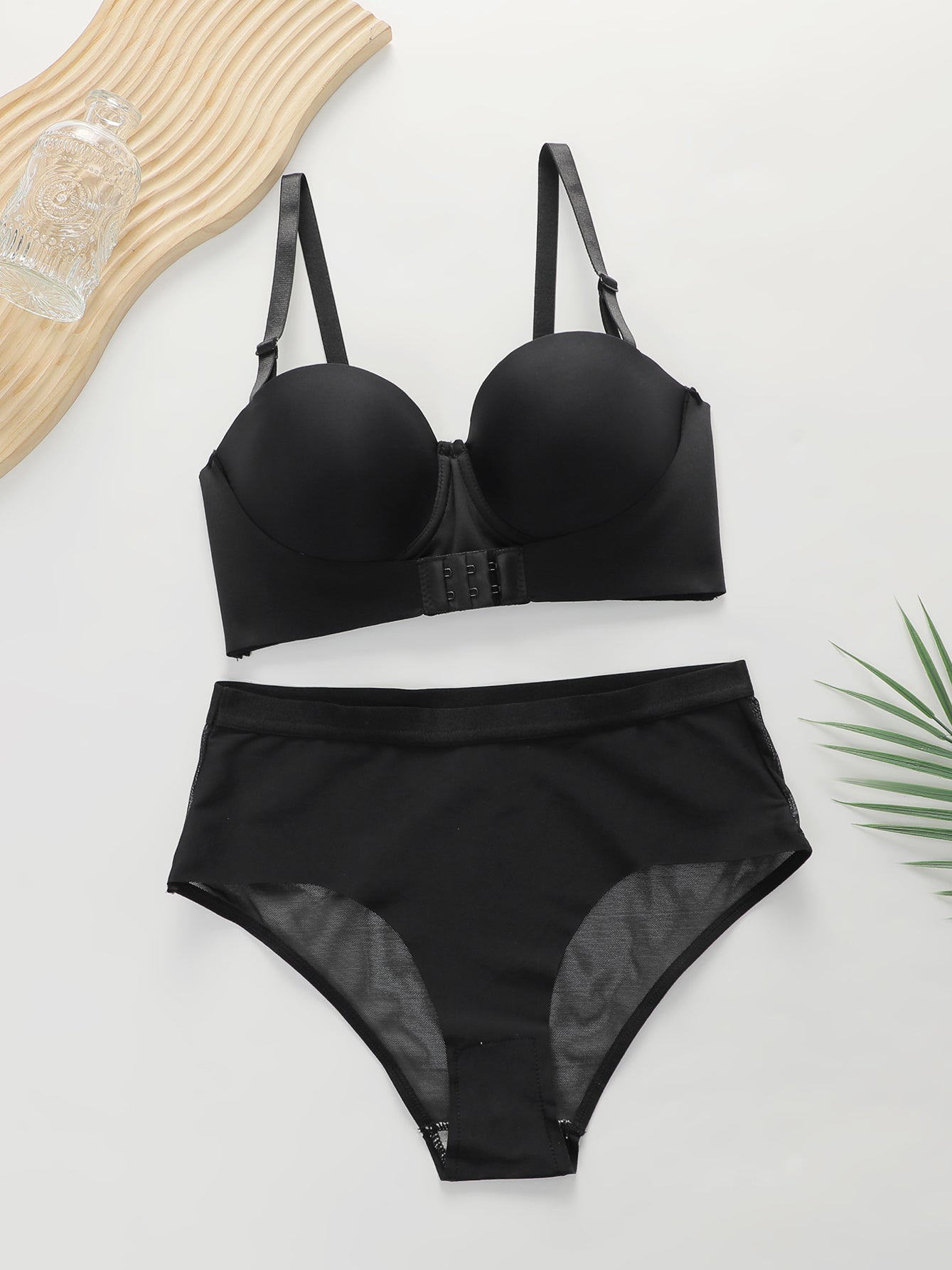 Black women's push-up bra and high-waisted underwear lingerie set on white background