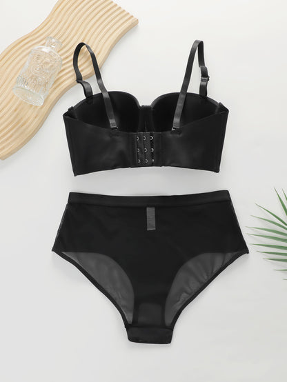 Black women's push-up bra and high-waisted mesh panties lingerie set flat lay with glass bottle and green leaf