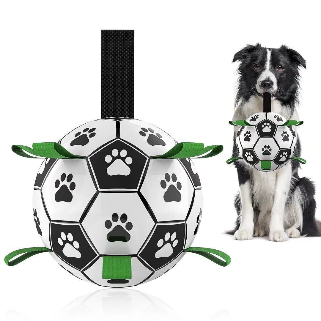 Durable black and white dog football toy with paw prints and green handles, held by a black and white Border Collie
