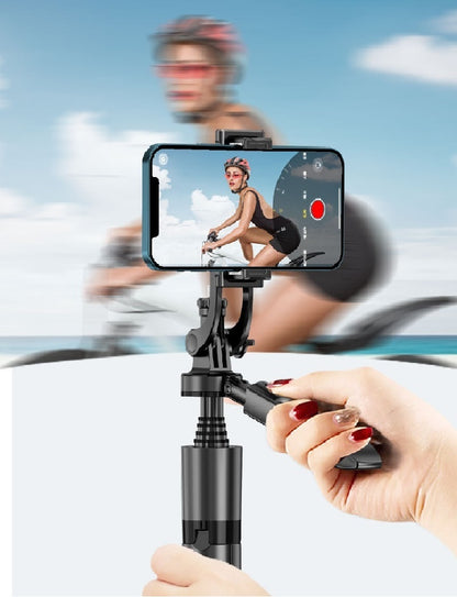Hand holding black AI smart gimbal with phone capturing cyclist wearing helmet and sunglasses